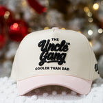 Beige and pink cap with 'The Uncle Gang Cooler Than Dad' text on a snowy background