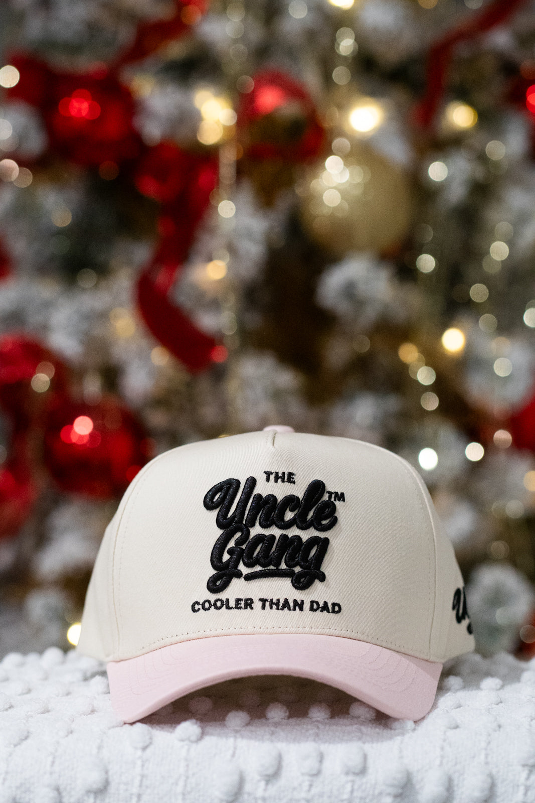 Beige cap with 'The Uncle Gang Cooler Than Dad' text in front of a decorated Christmas tree.
