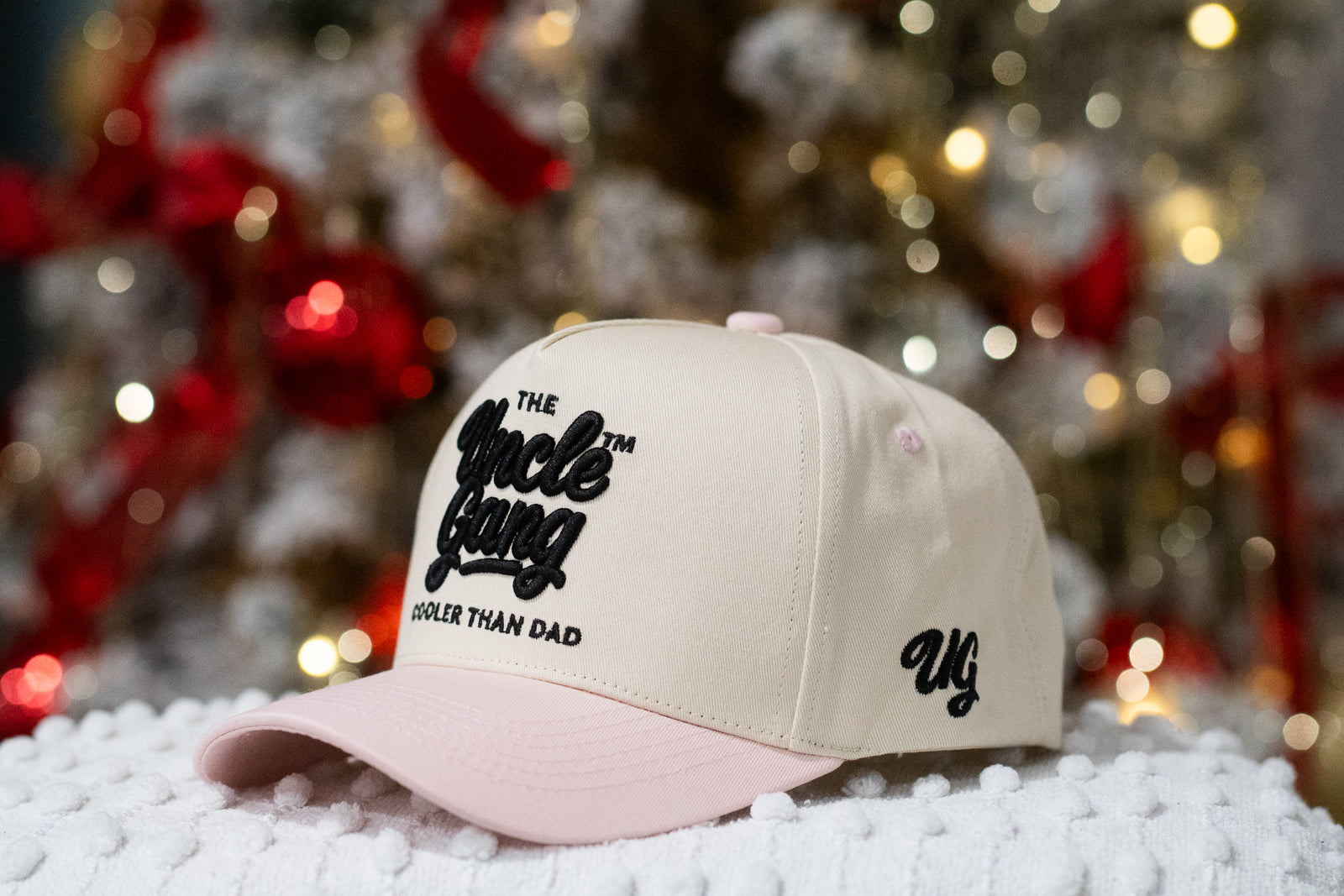 Beige cap with black text on a white surface with blurred festive background