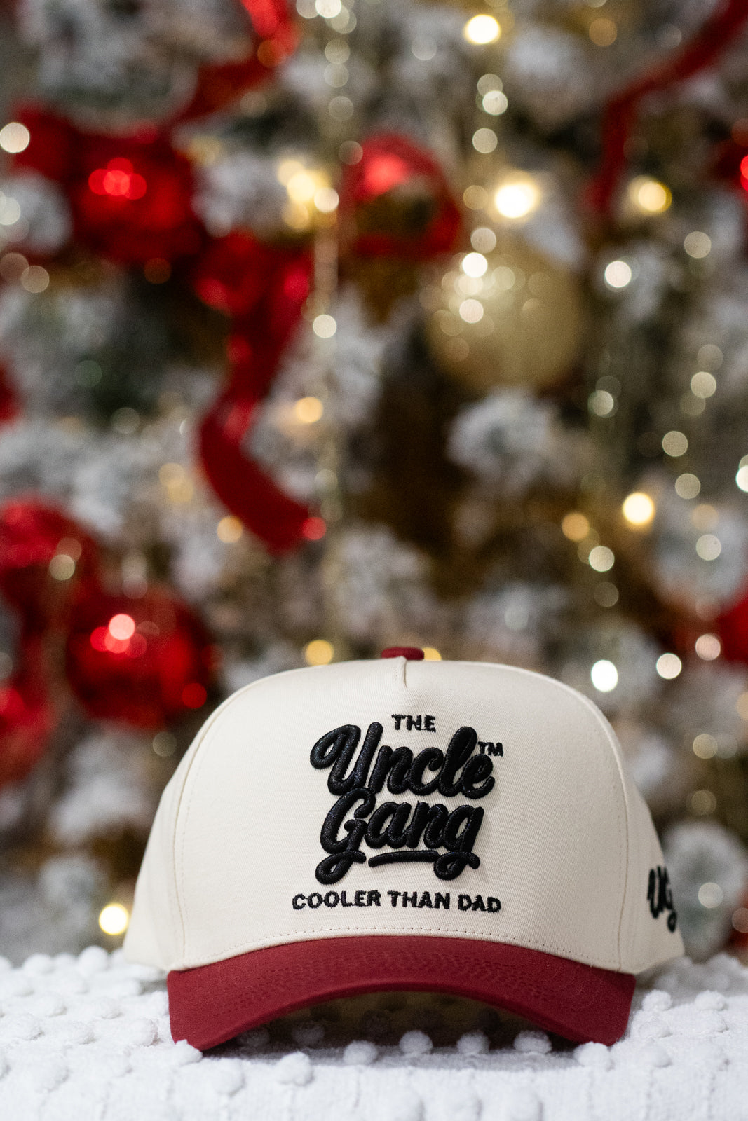 Cap with 'The Uncle Gang Cooler Than Dad' text in front of a decorated Christmas tree.
