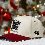 Cap with 'The Uncle Gang' logo on a snowy surface with blurred festive lights in the background