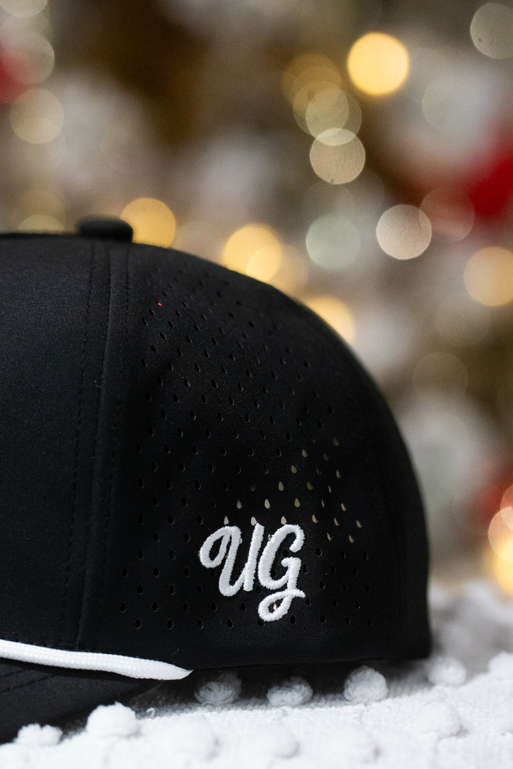 Black cap with 'UG' logo on a snowy background