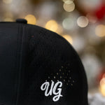 Black cap with 'UG' logo on a snowy background