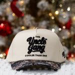 Beige cap with 'The Uncle Gang Cooler Than Dad' text in front of a Christmas tree.
