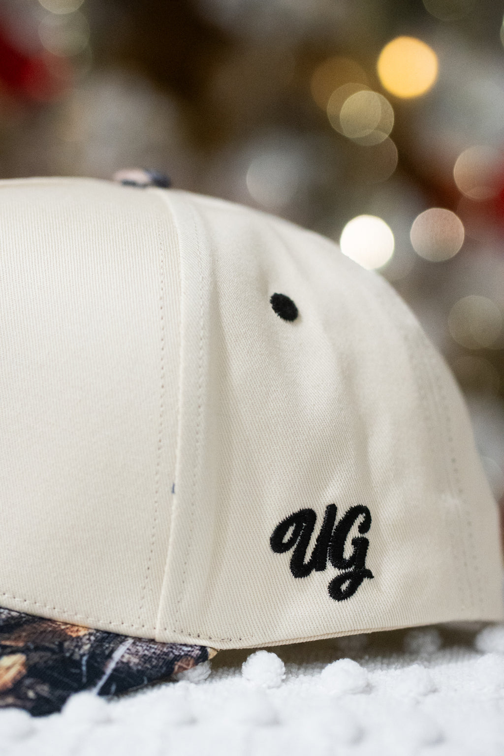 Beige cap with 'UG' logo on a blurred background